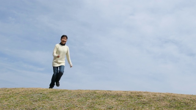 一个日本女孩在蓝天上奔跑视频素材