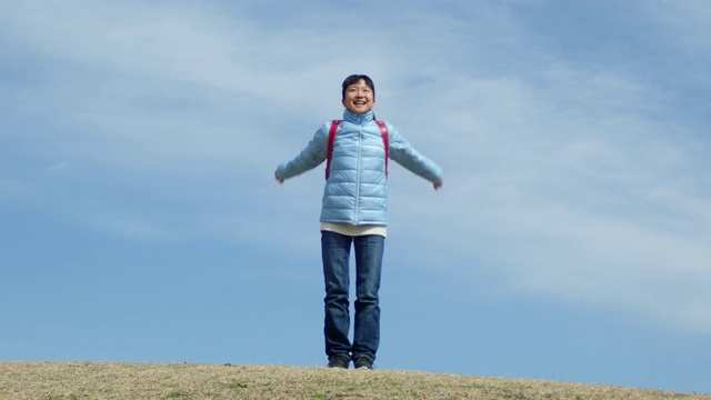 日本一名小学生在蓝天上举起双手鼓掌视频素材