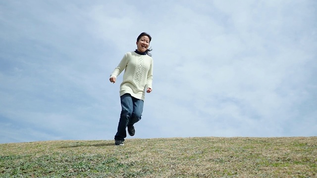 一个日本女孩在蓝天上奔跑视频素材