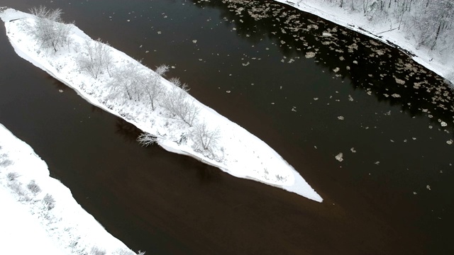 雪长小岛在冬季的河流，空中视频素材