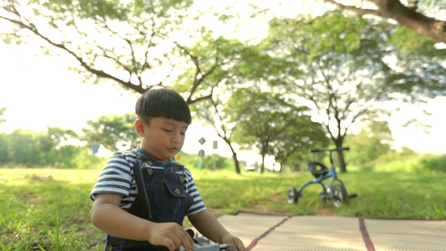 快乐时光，孩子在公园里玩飞机模型，概念孩子梦想，慢动作视频素材