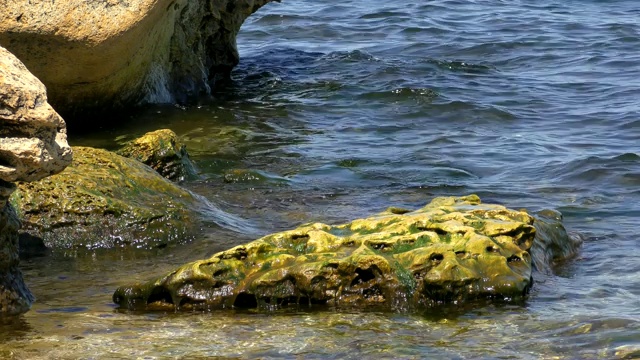 阳光明媚的黑海上的海水和海岸岩石视频素材