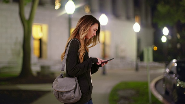 白人千禧一代女孩或学生晚上在校图书馆外发短信视频素材