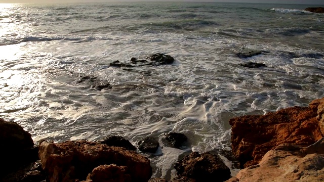 美丽而戏剧性的海浪在岩石海滩在夏天日出，慢镜头近景，地中海沿岸托雷维耶哈，阿利坎特，西班牙视频素材