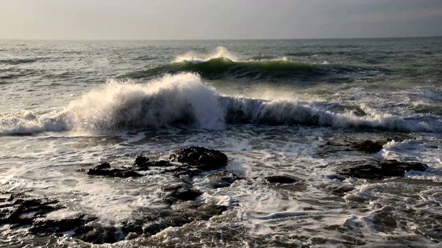 美丽而戏剧性的海浪在岩石海滩在夏天日出，慢镜头近景，地中海沿岸托雷维耶哈，阿利坎特，西班牙视频下载