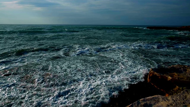 美丽而戏剧性的海浪在岩石海滩在夏天日出，慢镜头近景，地中海沿岸托雷维耶哈，阿利坎特，西班牙视频下载