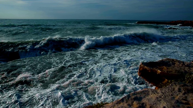 美丽而戏剧性的海浪在岩石海滩在夏天日出，慢镜头近景，地中海沿岸托雷维耶哈，阿利坎特，西班牙视频素材