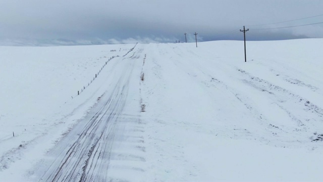 卡车向前的无人机拍摄的一个空，在一个国家的雪天下的道路视频素材