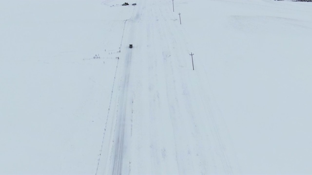 无人机拍摄的一辆卡车在该国一条被雪覆盖的道路上行驶视频素材