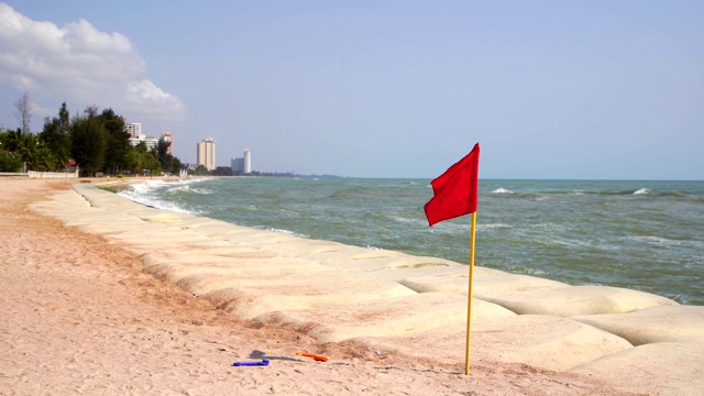 海边的红旗和沙滩上的沙袋警告不要游泳视频素材