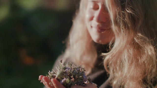 女人在院子里闻新鲜的香草视频素材