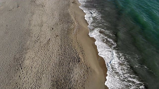 快速飞过带着海浪和泡沫撞击沙滩的浪花视频素材