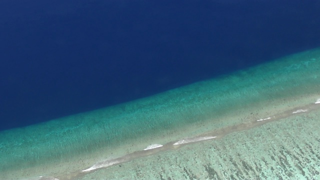 飞行接近热带沙滩和海浪，航拍马尔代夫的岛屿环礁，航拍马尔代夫群岛的一个热带小岛视频素材