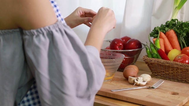 年轻女子在厨房做煎蛋卷。视频下载