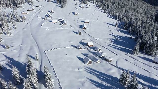 大雪覆盖的偏远村庄，宅基地在山上。4K无人机瞰图视频素材