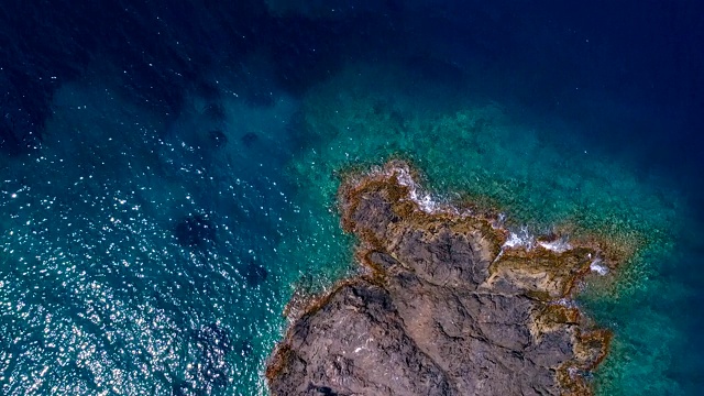 鸟瞰图上的一艘船在Cap De Creus海湾在西班牙。地中海的岩石和清澈的绿松石海水的美妙景色。夏日美景尽收眼底。视频素材