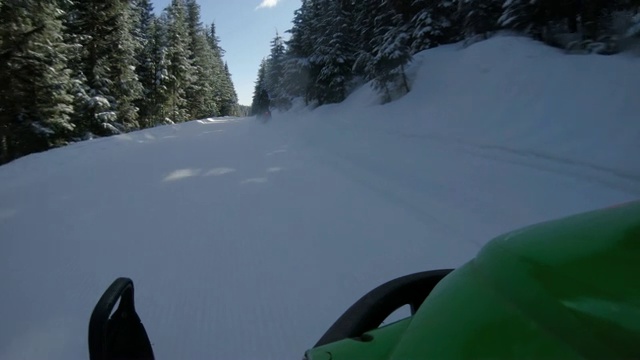 朋友骑雪地车探索高山森林POV视频素材