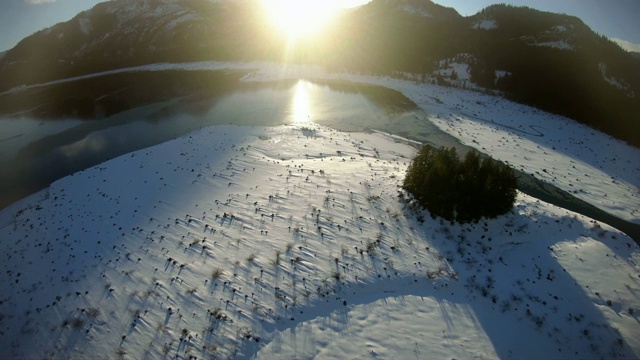 令人惊叹的雪山湖飞回无人机拍摄在金色的阳光视频素材