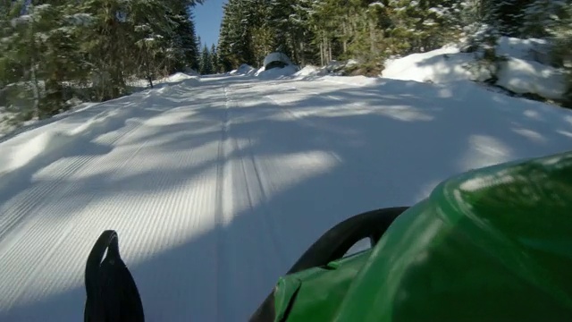 冬季仙境雪地摩托低POV在阳光小径视频素材