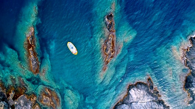 鸟瞰图上的一艘船在Cap De Creus海湾在西班牙。美丽的风景岩石和清澈的地中海绿松石水。夏日美景尽收眼底。视频素材