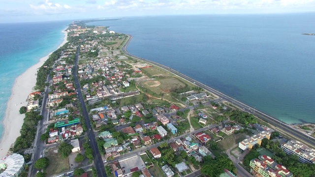 一架无人机正在大西洋海湾的热带岛屿附近移动。鸟瞰主要道路，街道，海岸线，房屋。视频素材