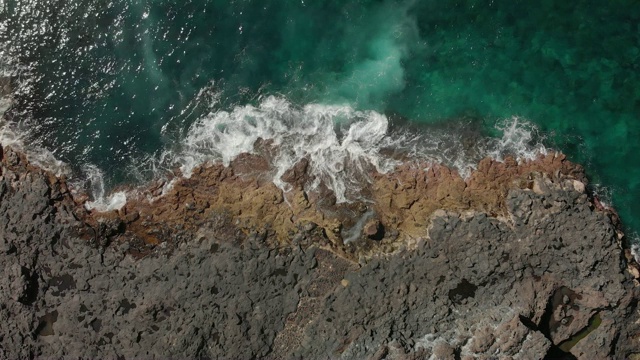 立面图。蓝色和蓝绿色的海洋，海水泡沫和火山海岸线视频素材