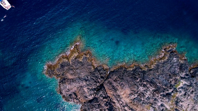 鸟瞰图上的一艘船在Cap De Creus海湾在西班牙。地中海的岩石和清澈的绿松石海水的美妙景色。完美的景色，暑假。视频素材