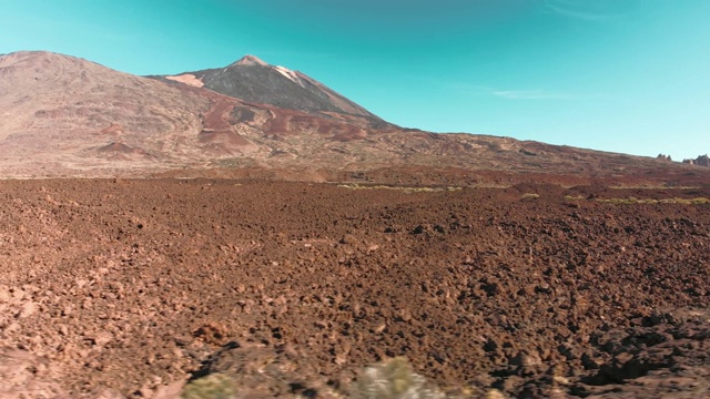 空中无人机拍摄。红色的火星沙漠火山景观。蓝色的天空映衬着石头和一座火山山。殖民和迁移到火星和其他星球的概念。低跨度的石谷。移动了视频素材