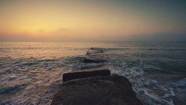 海面和海滩上的日出。当太阳从地平线升起时，海浪在跳舞视频素材