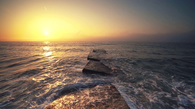 海面和海滩上的日出。当太阳从地平线升起时，海浪在跳舞视频素材