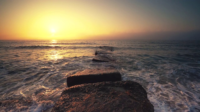 海面和海滩上的日出。当太阳从地平线升起时，海浪在跳舞视频素材