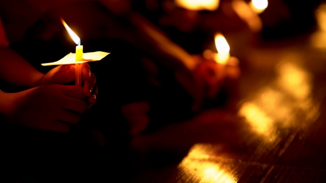 蜡烛火火焰燃烧在手上的人和圆蜡烛在晚上视频素材