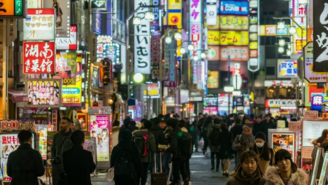 4K日本东京新宿，歌舞伎町夜晚的一段时间，人群不明，行人行走在马路上，车水马龙。日本霓虹街文化与购物概念视频素材