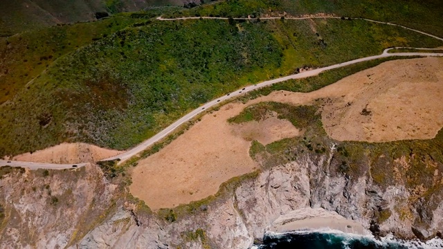 美丽的无人机俯视图汽车在惊人的1号公路靠近太平洋阳光明媚的风景全景大苏尔加利福尼亚。视频素材