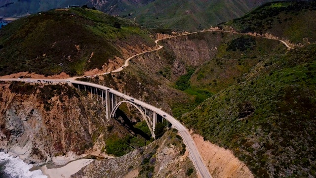 无人机飞过著名的比克斯比峡谷大桥和1号高速公路，阳光明媚的夏天风景如画的大苏尔加州。视频素材