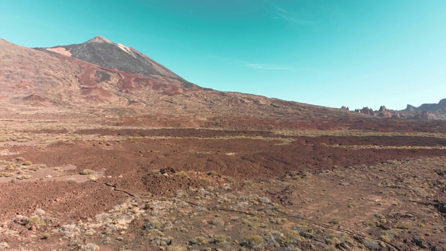 空中无人机拍摄。加那利群岛，泰德火山。国家公园。蓝色的天空映衬着石头和山脉。孤独的概念，殖民和搬迁到火星和其他星球。低而缓慢地飞过山谷。反向运动视频素材