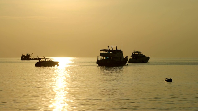 海上金色夕阳下的船的剪影视频素材