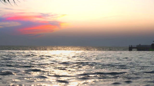 热带棕榈树与阳光和游泳池附近的海滩在夏天的背景。视频下载