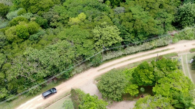 鸟瞰图的4x4汽车上的小砾石路在一个绿色的热带山谷在巴西视频素材