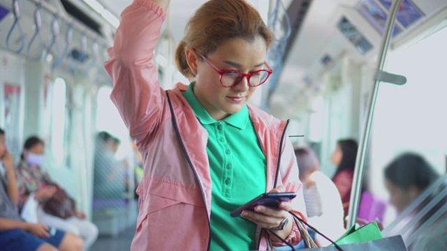 年轻女子在乘坐地铁时使用智能手机视频素材