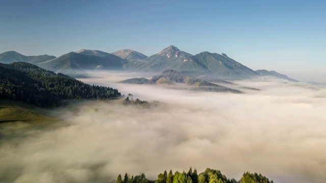 在阳光明媚的早晨飞过多雾的山野视频素材