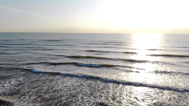 海滩上的日出。沙滩上的速动摄影机。模仿海滩上的汽车。太阳后面的海浪接近海岸。太阳在水中的反射。视频素材