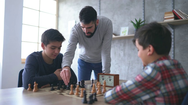 两个男孩和象棋老师下棋视频素材