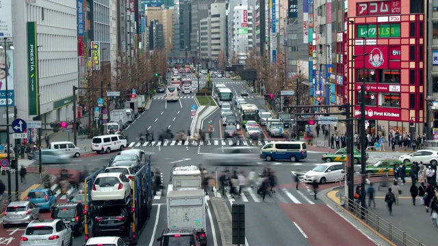 在日本东京新宿一条繁忙的街道上，可以看到繁忙的车流和行人过马路的画面视频素材