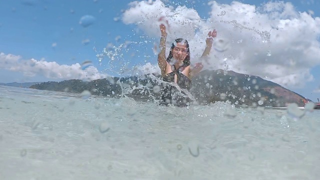 夏天亚洲女人有乐趣溅水和放松在海滩上超级慢动作视频素材