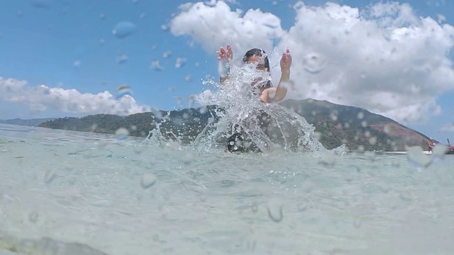 夏天亚洲女人有乐趣溅水和放松在海滩上超级慢动作视频素材