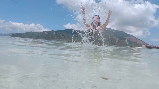 夏天亚洲女人有乐趣溅水和放松在海滩上超级慢动作视频素材