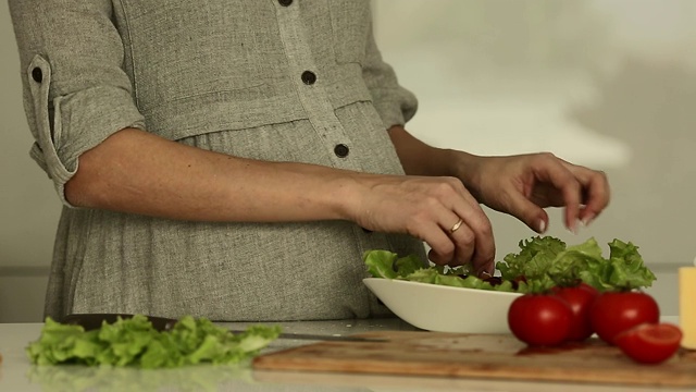 孕妇在厨房烹饪绿色沙拉-正面视图，视频素材