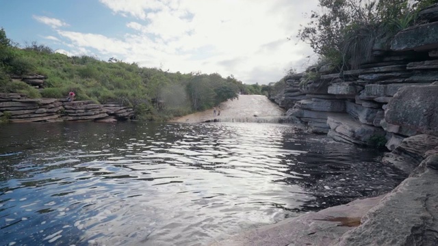 慢镜头:在巴西的Chapada，河流与小波浪被平坦的，堆叠的石头包围视频素材