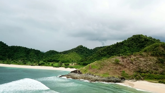 空中:海浪轻轻拍打着龙目岛的海岸线和郁郁葱葱的风景，巴厘岛视频素材